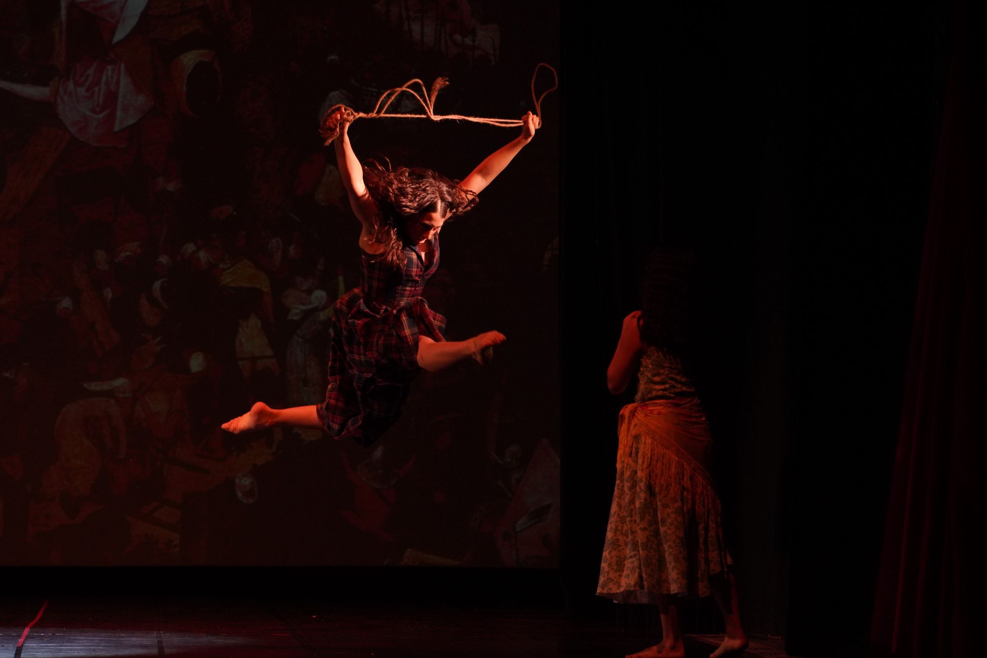 Danzatrice in salto con una corda durante uno spettacolo di danza contemporanea