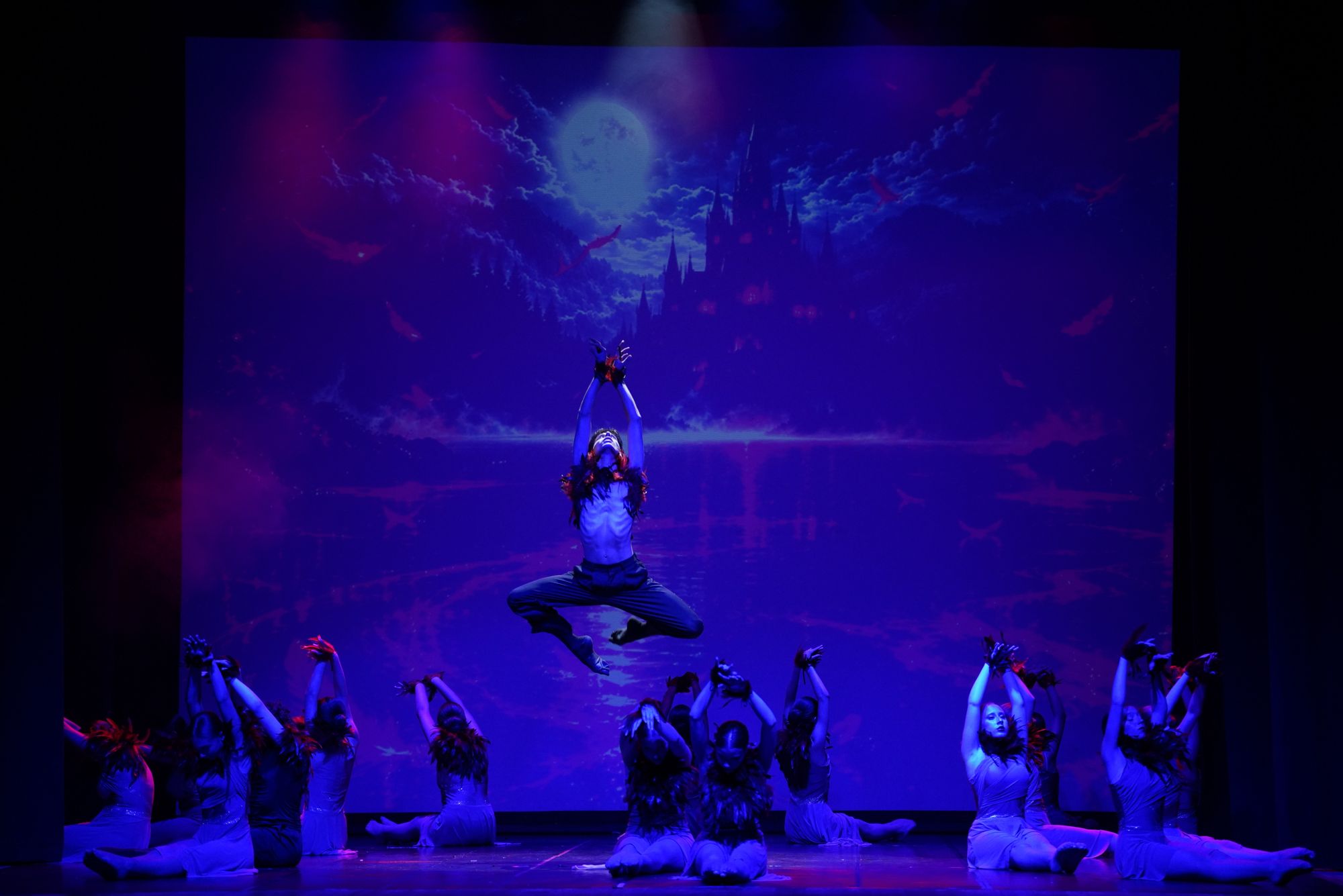 Danzatore in salto durante uno spettacolo di danza, scenografia notturna con luna