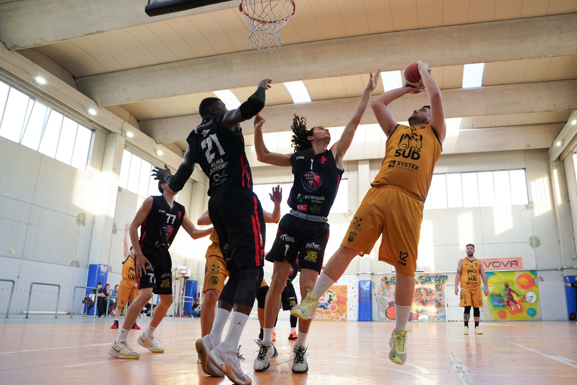 Tiro contrastato sotto canestro durante una partita di basket